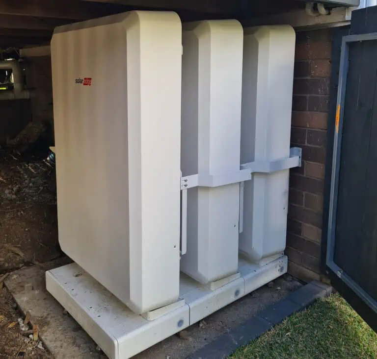 Solar batteries stored in fenced area in residential backyard