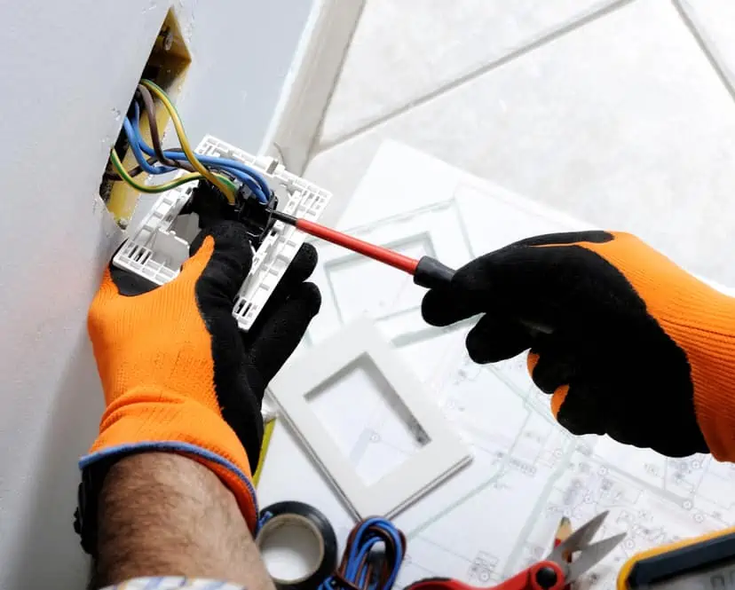 Electrician working safely on switches and sockets of a residential electrical system